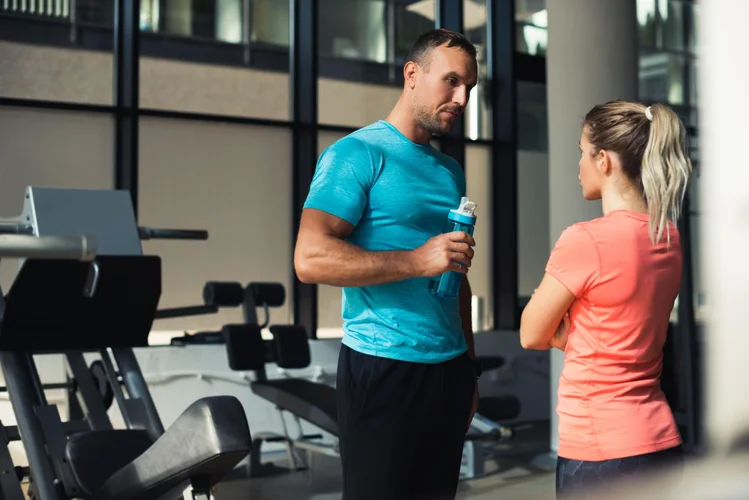 Manlig nybörjare följer ett enkelt gymprogram bredvid vikter.